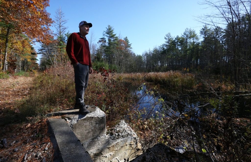 Jon Kachmar, executive director of the Eastern Trail Alliance, stands on a culvert at West Brook that runs under the next phase of the off-road trail expansion.